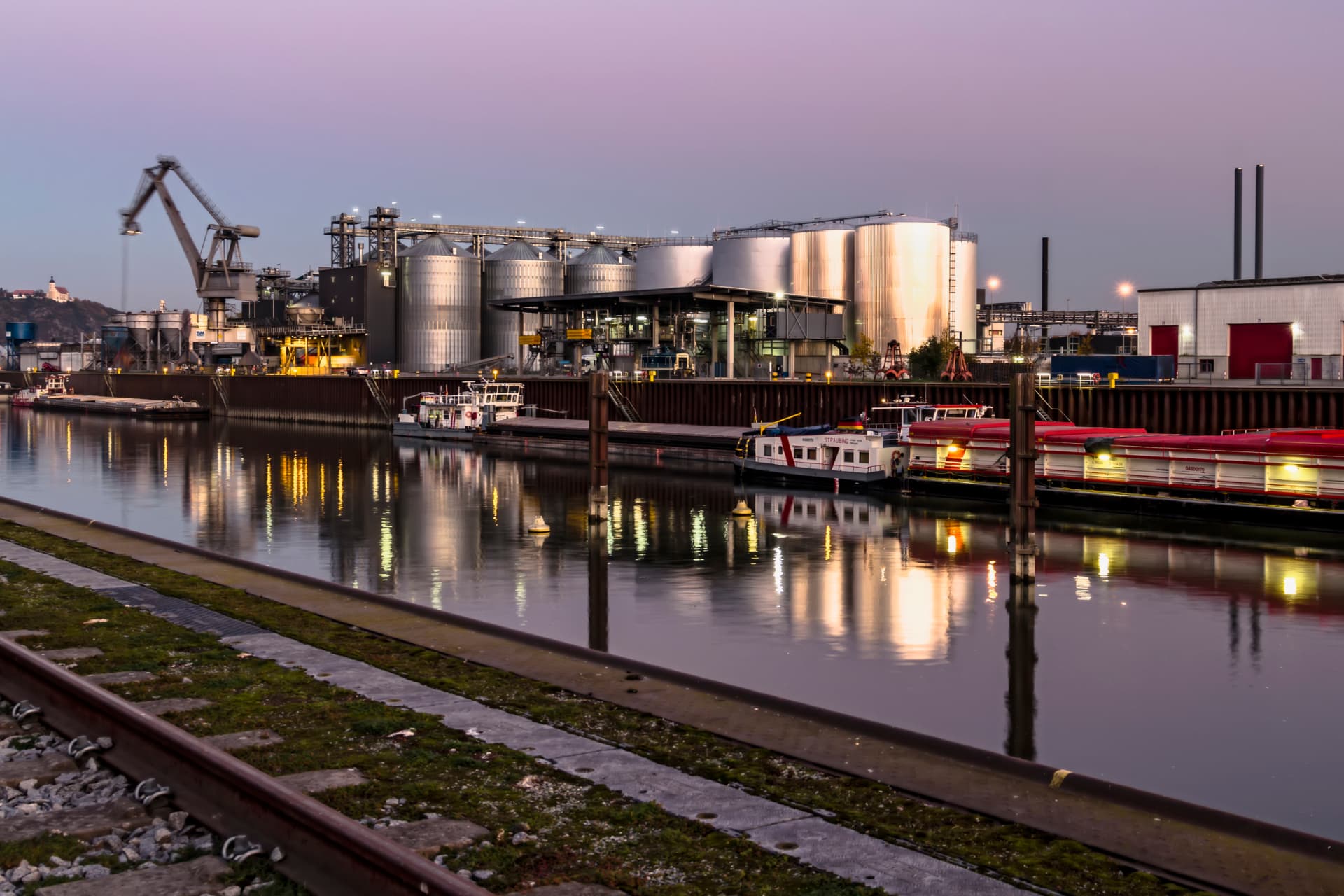Hafen Straubing am Donauufer mit Silos und Industriegebäuden in der Abenddämmerung