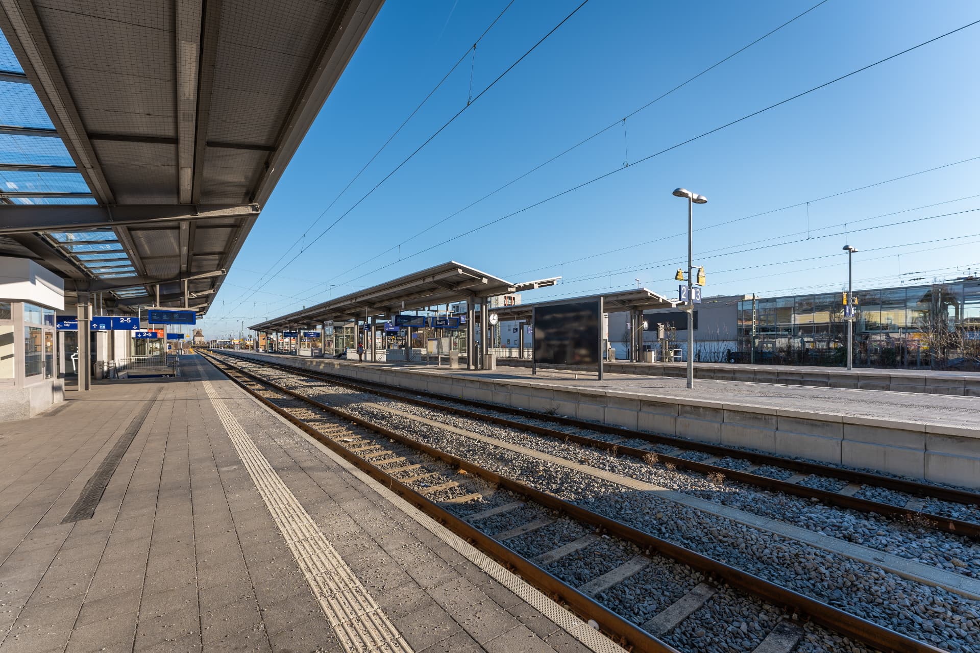 Bahnsteig am Bahnhof Straubing mit Gleisen im Sonnenlicht